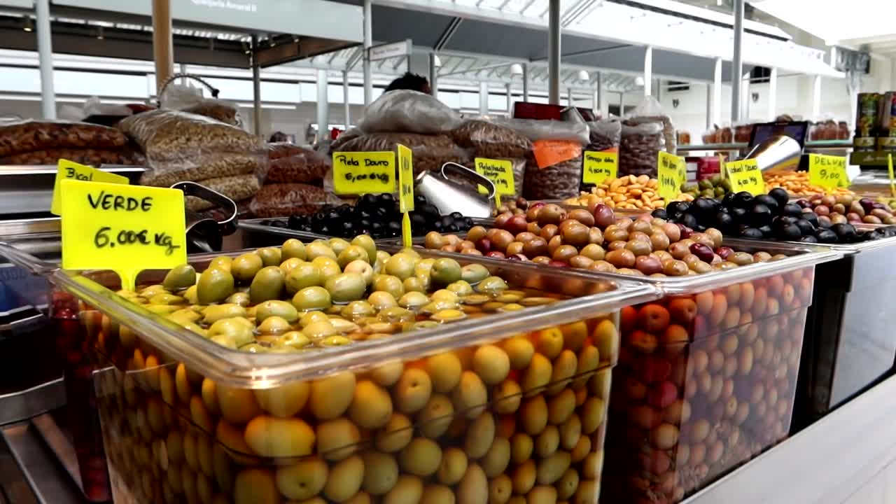 diferentes tipos de aceitunas de portugal a la venta en el mercado de bolhao, vista en movimiento
