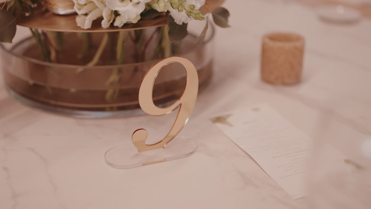 golden number nine table marker with soft wedding floral centerpiece