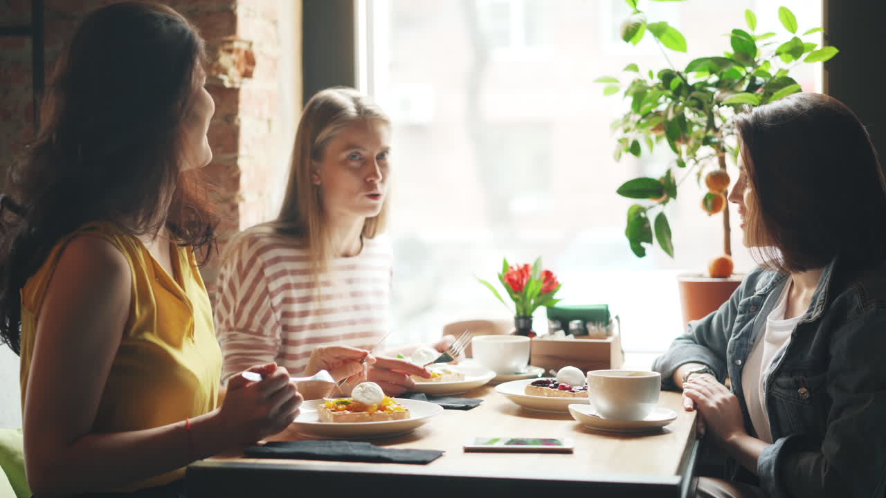 친구 들 이 카페 에서 디저트 와 대화 를 즐기고 있다