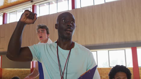 diverse male basketball team and coach celebrating together