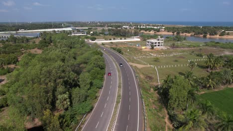 aerial pursuit of a red car on a winding roadway