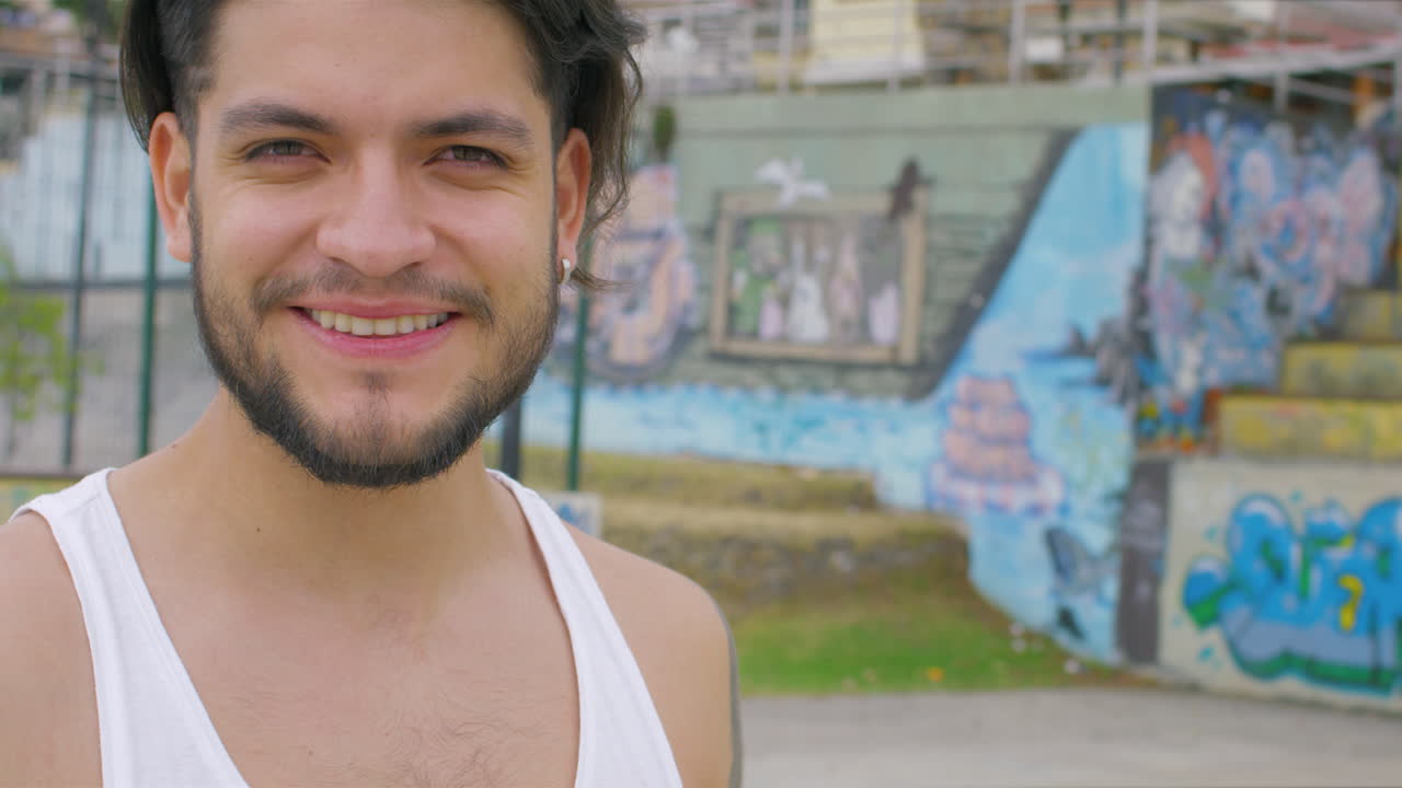 chico guapo bebiendo agua fresca de una botella de plástico en un parque de patinaje