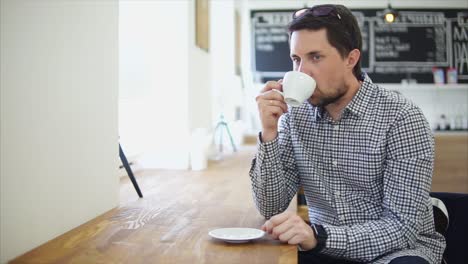 hombre bebiendo café en una cafetería
