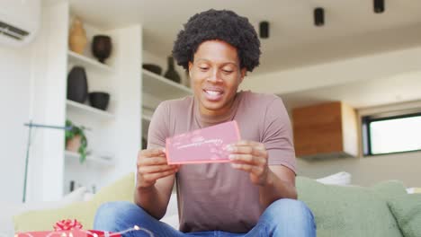 African-american-man-opening-gift-at-home