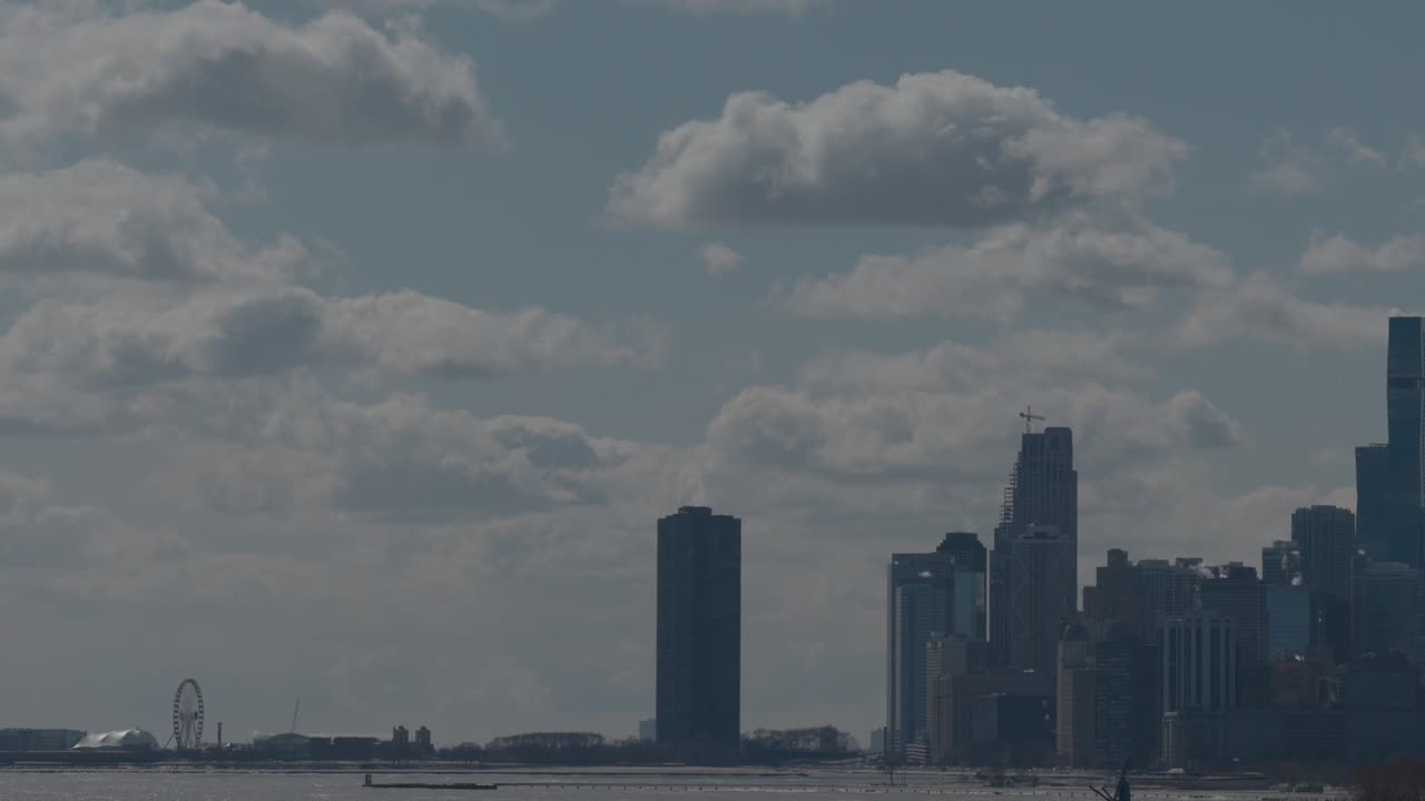 Una toma de dron ascendente desde detrás de los árboles del Navy Pier y otros edificios de Chicago a lo largo del lago en un día soleado de invierno