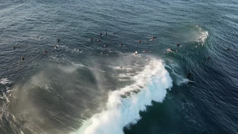 Vista-Aérea-Que-Muestra-A-Muchos-Surfistas-Esperando-La-Ola-Perfecta-En-Australia-Durante-La-Puesta-De-Sol