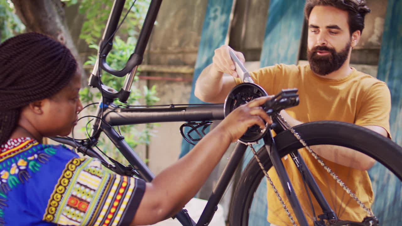 pareja engrasando una cadena de bicicleta en el patio
