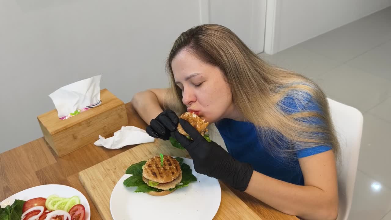женщина ест вкусный бургер.