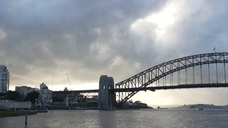 a train passes over sydney harbour bridge during the sunrise, australia