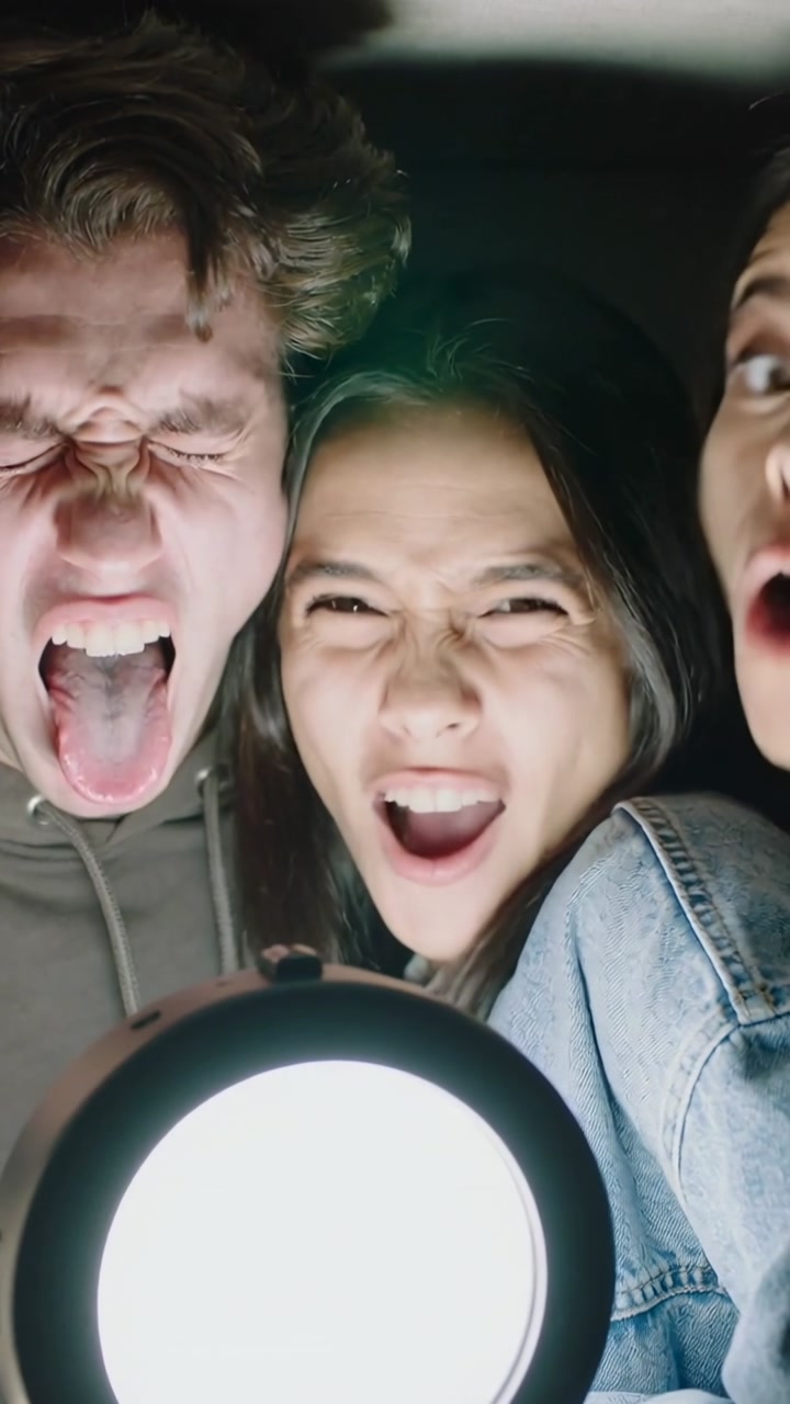 Vertical video: Reacting to ring light, trio huddling in car making silly faces for selfie