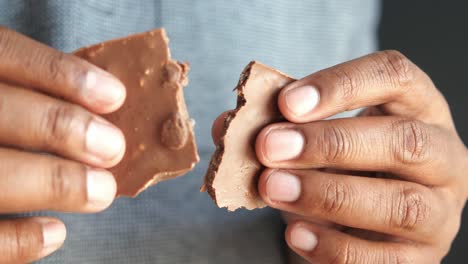 person holding a broken chocolate bar