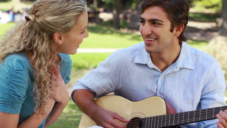 el novio toca la guitarra para su novia.