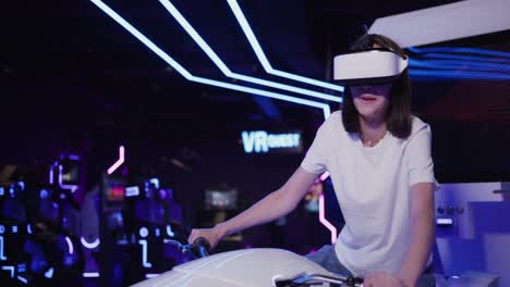 woman experiencing vr motorcycle simulator in an arcade