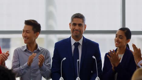 Businessman-standing-on-the-podium-with-his-colleagues-in-the-business-seminar-4k