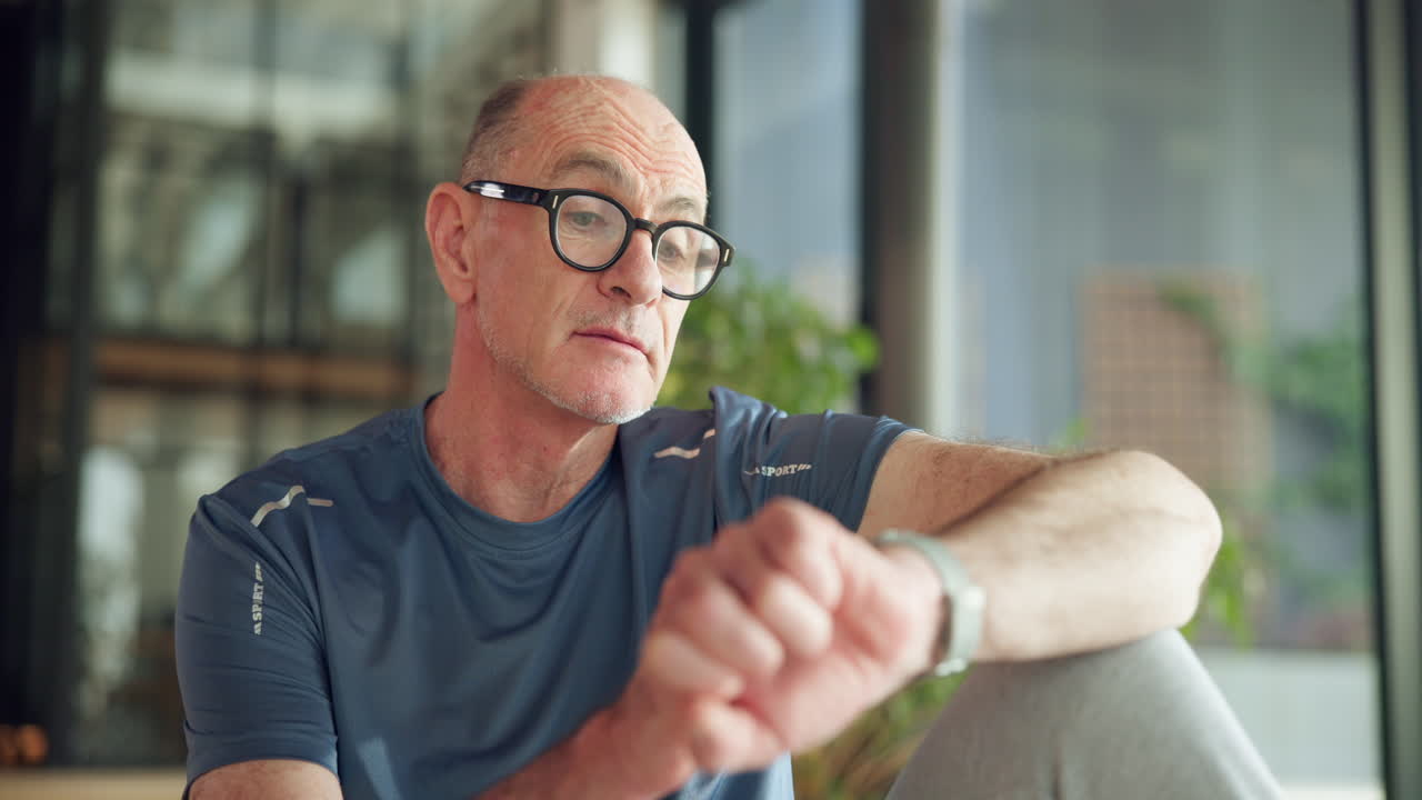 Senior Man Checking Fitness Tracker on His Wrist Indoors
