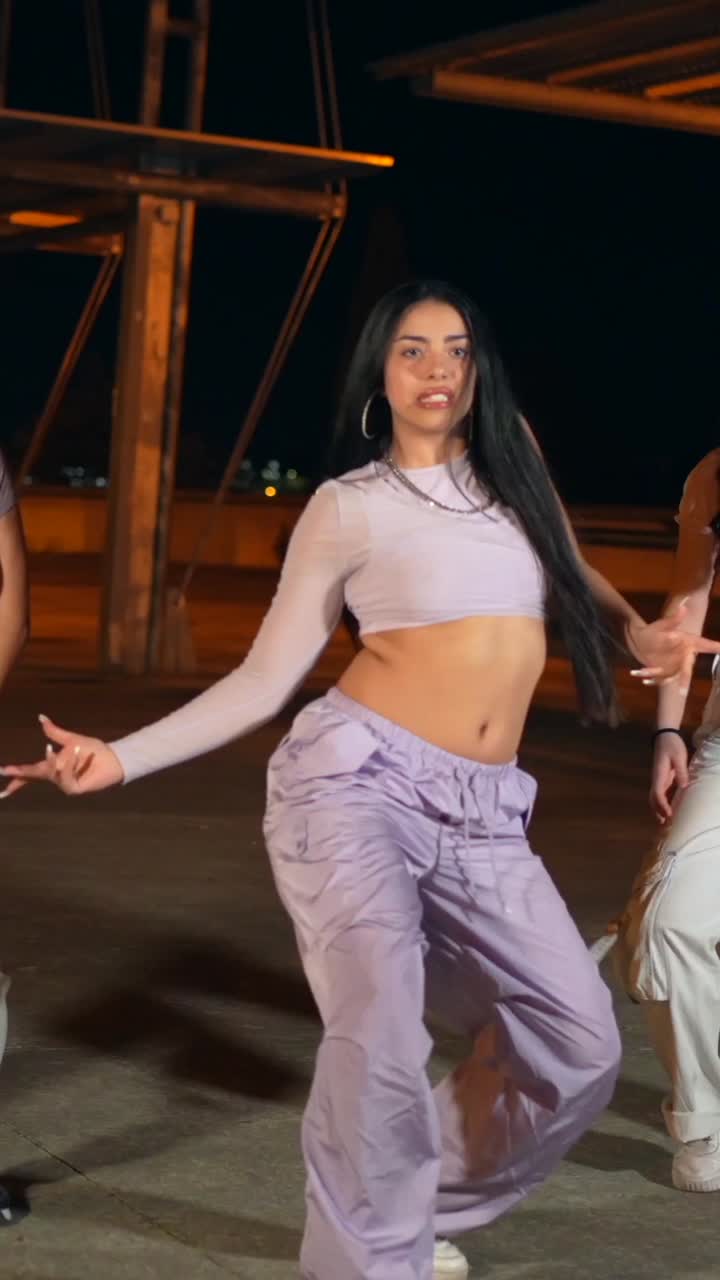 Young women dancing outdoors at night
