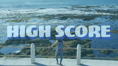 animation of high score text over woman standing on promenade, taking break in exercise by seaside