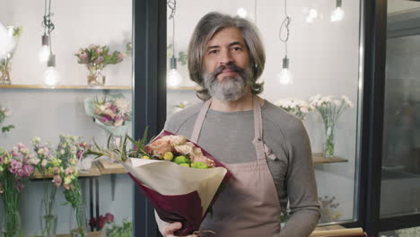 portrait of male florist with bouquet of flowers