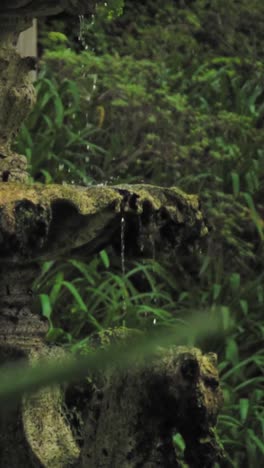 water dripping from a stone fountain in a garden