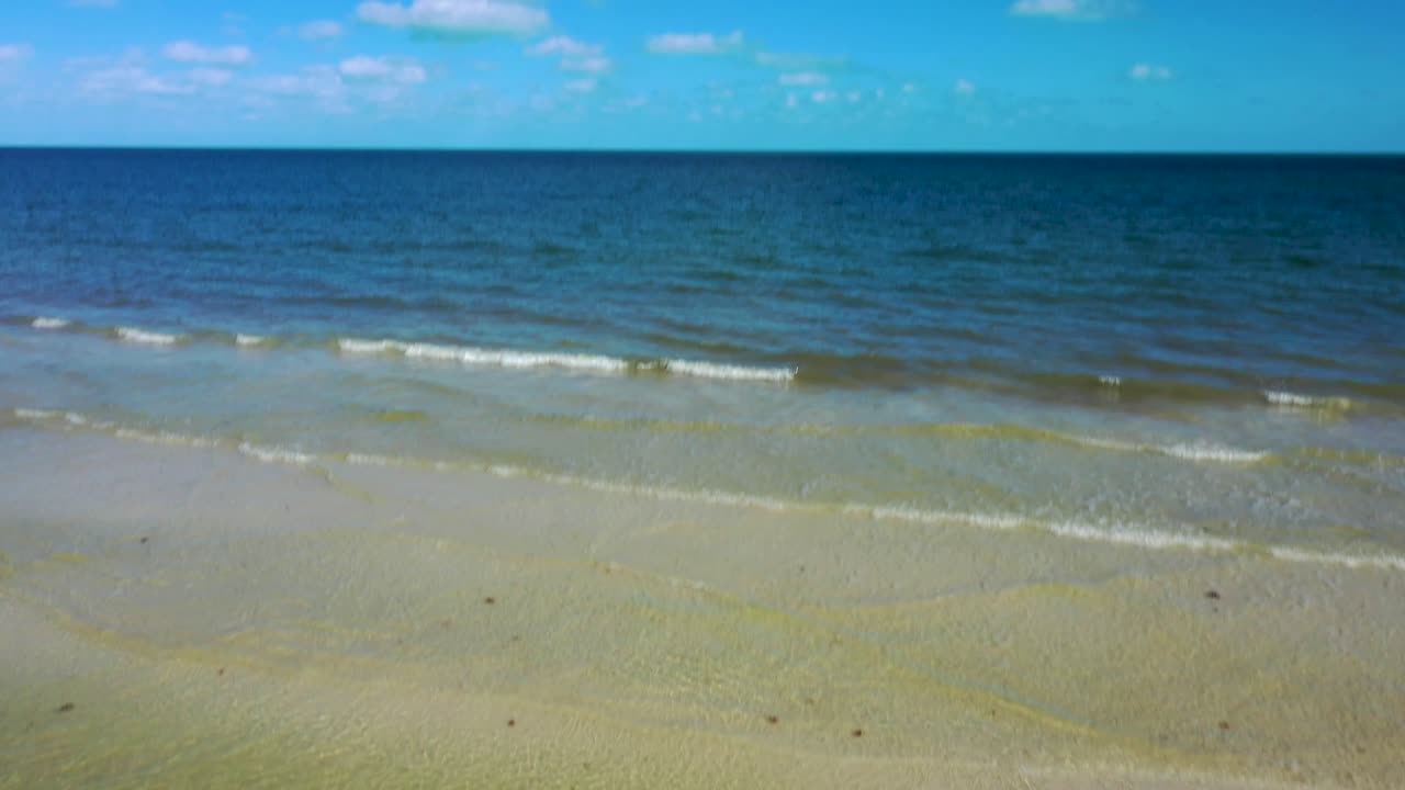 카메라는 해변의 모래에 쓰여진 여행에서 바다를 보여주는 수평선까지 기울어집니다