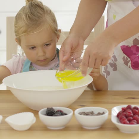 Cute-baby-helps-measure-ingredients-in-kitchen