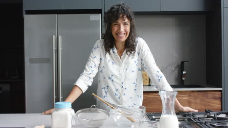 Retrato-De-Una-Mujer-Birracial-Feliz-Horneando-En-La-Cocina,-Cámara-Lenta