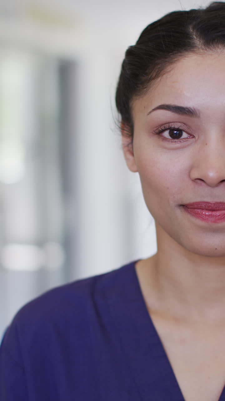 Vertical video of portrait of happy biracial female doctor
