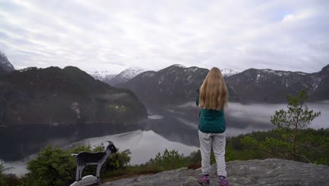 female photographer facing away photographs veafjorden fjord, norway