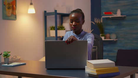 African-woman-coming-in-living-room-and-typing-on-computer