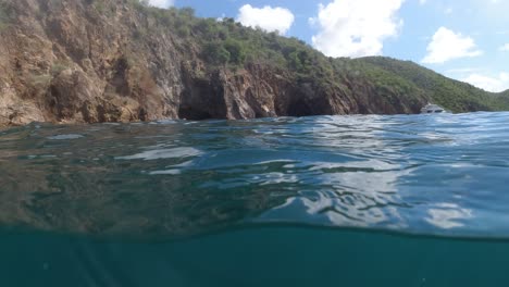 the-rocky-shores-and-luxury-sailing-yachts-of-the-British-Virgin-Islands-through-a-bubble-lens-that-shows-both-above-and-below-water-at-the-same-time