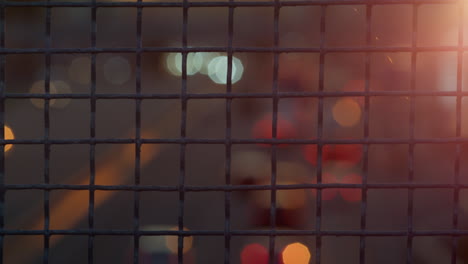 Closeup-metallic-squared-netting-fence-in-golden-sunlight.-Big-city-life-concept