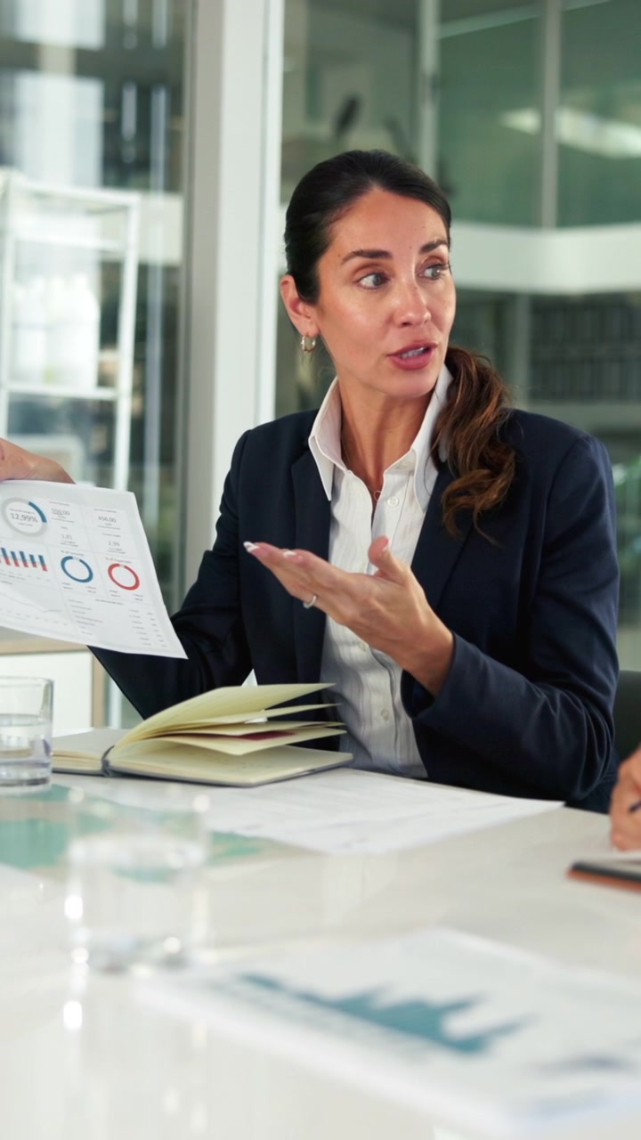 Businesswoman Presenting Financial Charts in a Professional Meeting