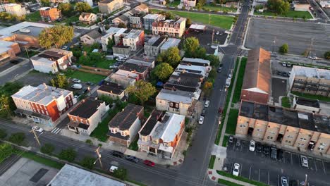 historic colonial and victorian townhouses or row pf homes in america. descend drone shot. sunset time in new jersey. parked cars on area along rusty apartment complex in suburb