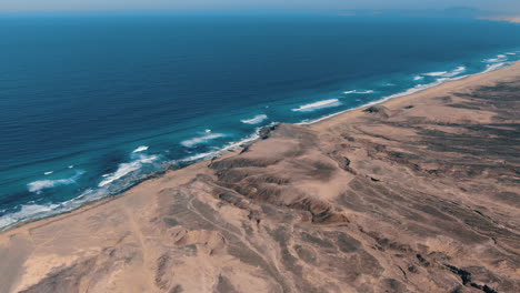 Toma-Aérea-Circular-A-Gran-Altura-Sobre-El-Parque-Natural-De-Cofete-En-La-Isla-De-Fuerteventura-Y-Donde-Se-Puede-Ver-Su-Fantástica-Playa-Y-Las-Hermosas-Montañas-De-La-Zona