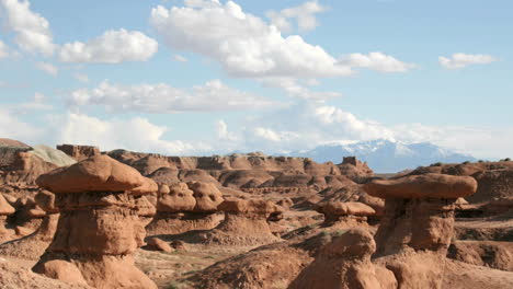 nubes blancas flotan en un cielo azul sobre el parque estatal goblin valley