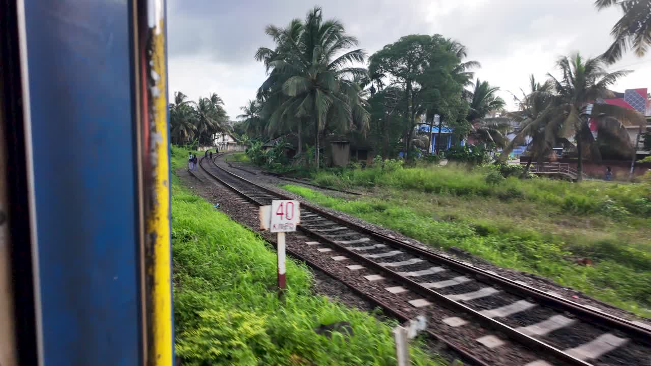 Scenic railway journey through sri lanka's countryside, offering a passenger's perspective of the vibrant greenery and palm trees