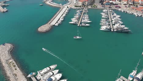 aerial over anchored motorboats, yachts and sailboats in organized manner on the marina of coastal city at adriatic sea, croatia