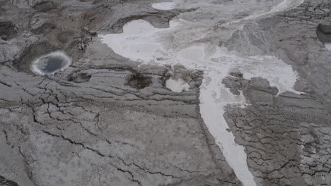 El-Agua-De-Inundación-Llena-Pequeños-Sumideros,-En-El-Desierto-Del-Mar-Muerto,-Tiro-Aéreo