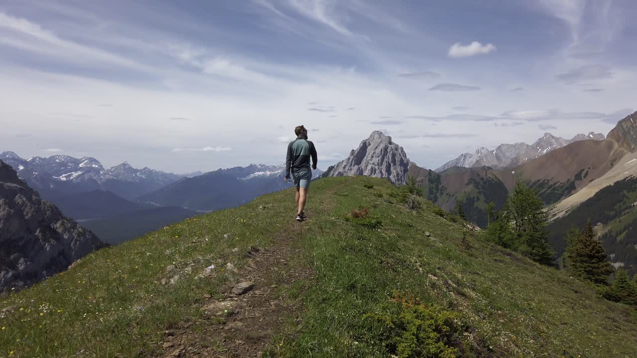 excursionista caminando en la cima de un avión de montaña, montañas rocosas, kananaskis, alberta, canadá