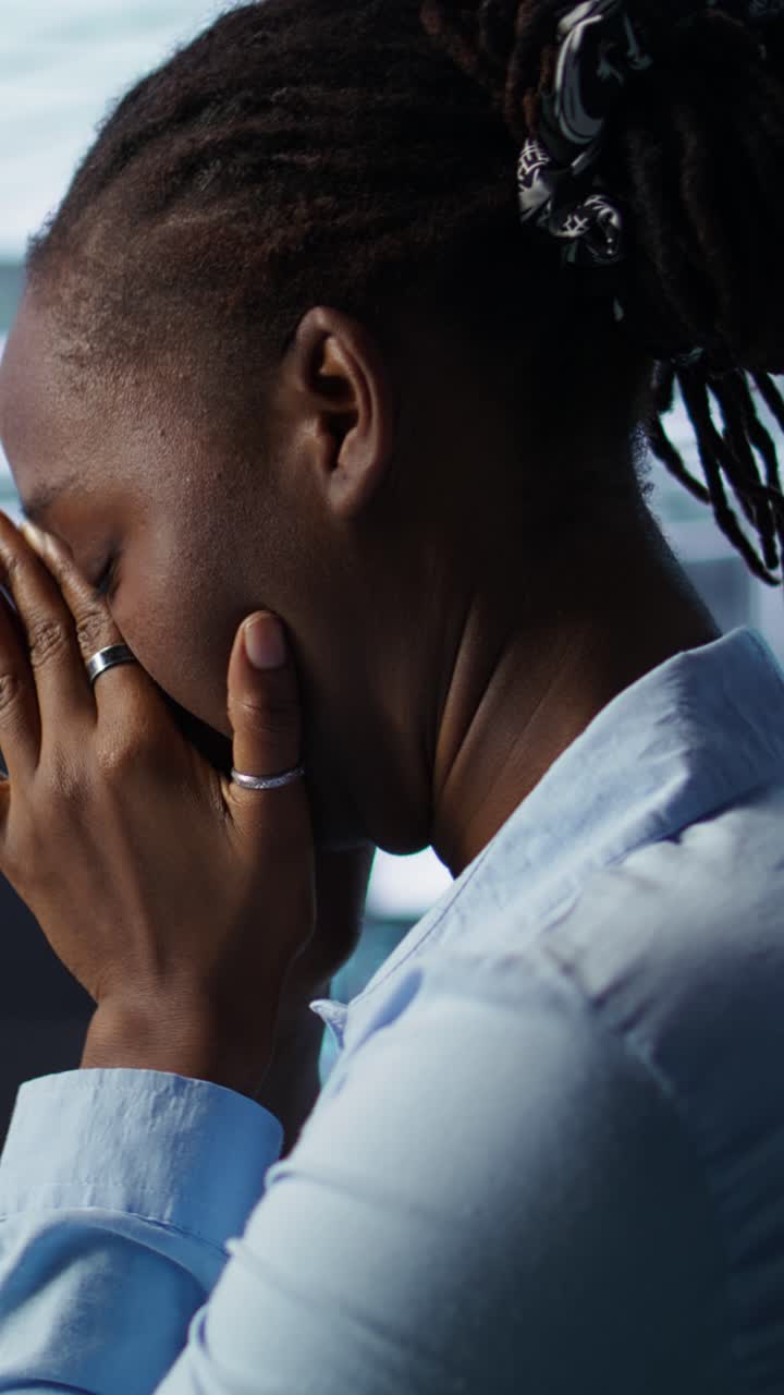 Mulher negra esfregando os olhos cansados no escritório