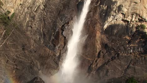 se forma un arco iris cerca del fondo de una cascada