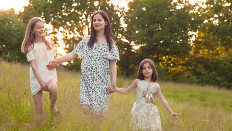 mother and daughters walking in a field