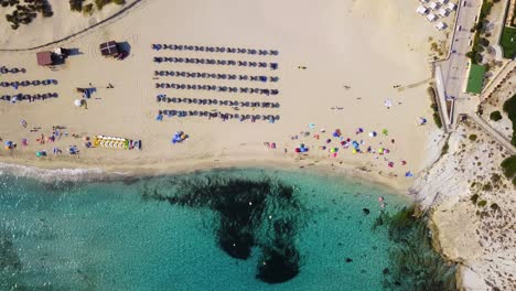 Overhead-drone-shot-over-the-beachfront-of-Cala-Mesquida,-a-perfect-summer-getaway-in-the-Mediterranean-island-of-Mallorca,-Spain