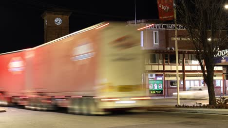 vehicles passing by a corner store at night