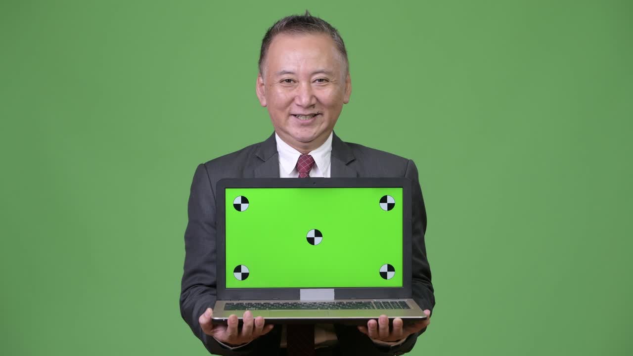 노트북을 보여주는 성숙한 일본인 사업가