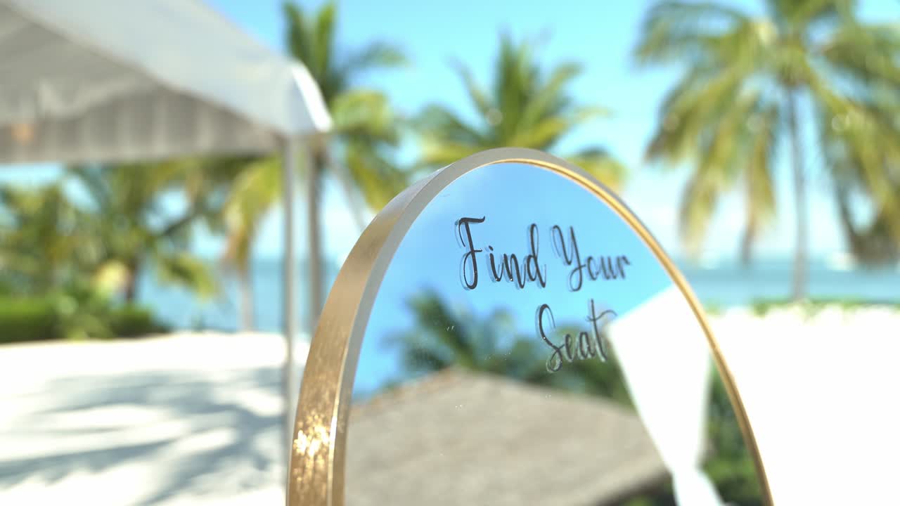 Panoramica di una lussuosa location per matrimoni a specchio sulla spiaggia in una giornata di sole, con pace e tranquillità, sedute all'aperto, spiaggia sabbiosa e allestimento per fidanzamenti con tavoli