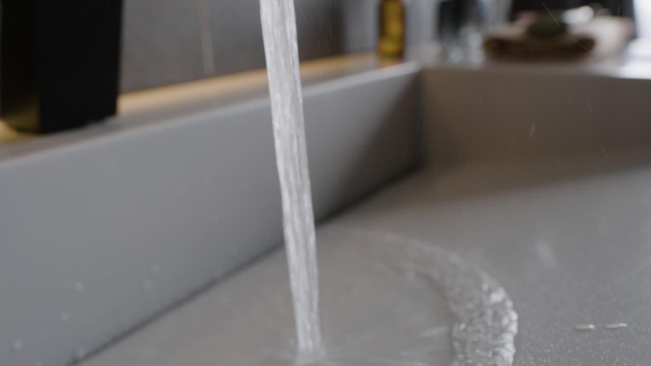 Water running from a faucet into a sink