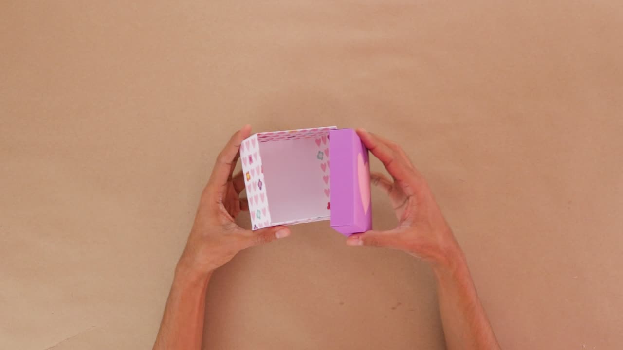 Holding and opening handmade cardboard valentines day gift box