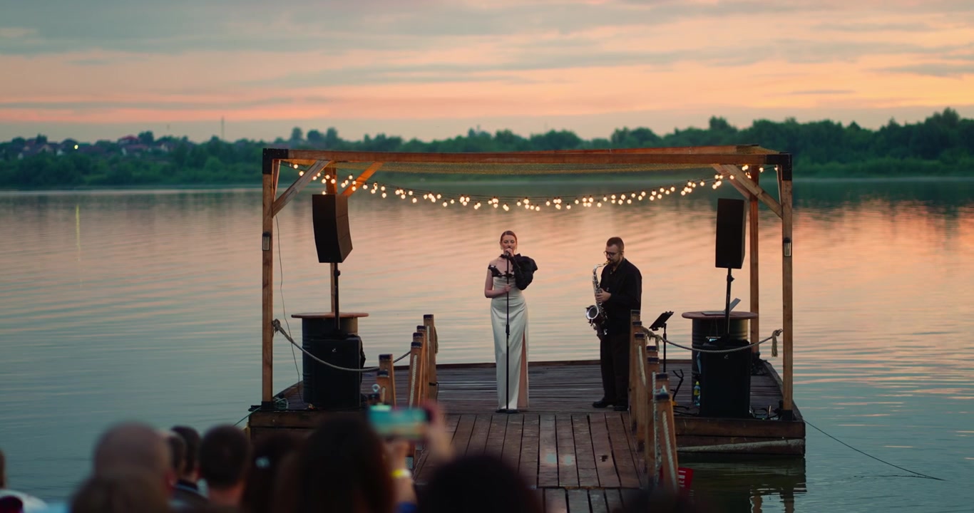 Musicians Performing on a Floating Dock at Sunset