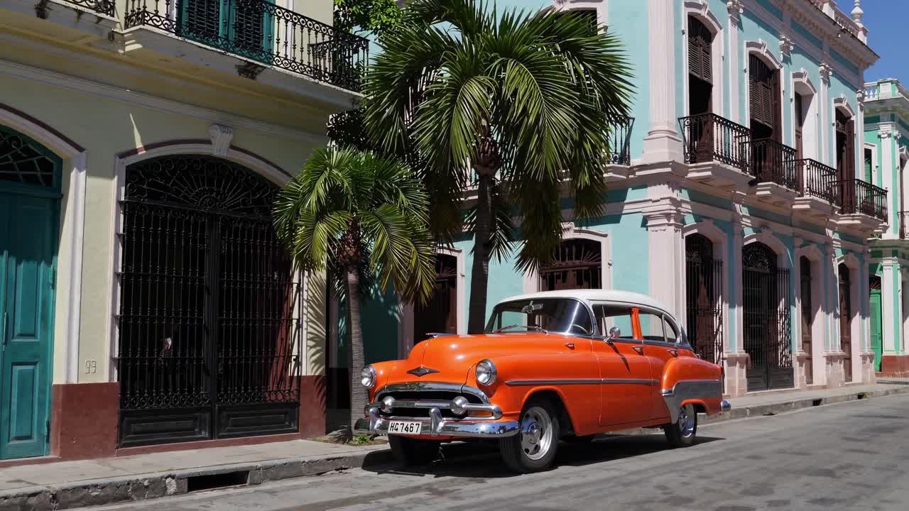 coche naranja vintage en la calle cubana de colores